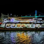 Princesa Dinner Cruise in Goa illuminated at night with colorful lights reflecting on the Mandovi River.