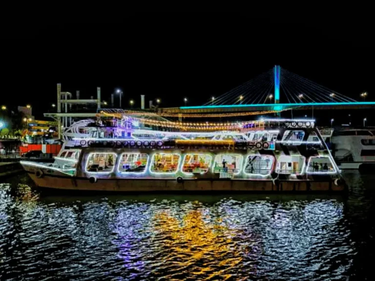 Princesa Dinner Cruise in Goa illuminated at night with colorful lights reflecting on the Mandovi River.