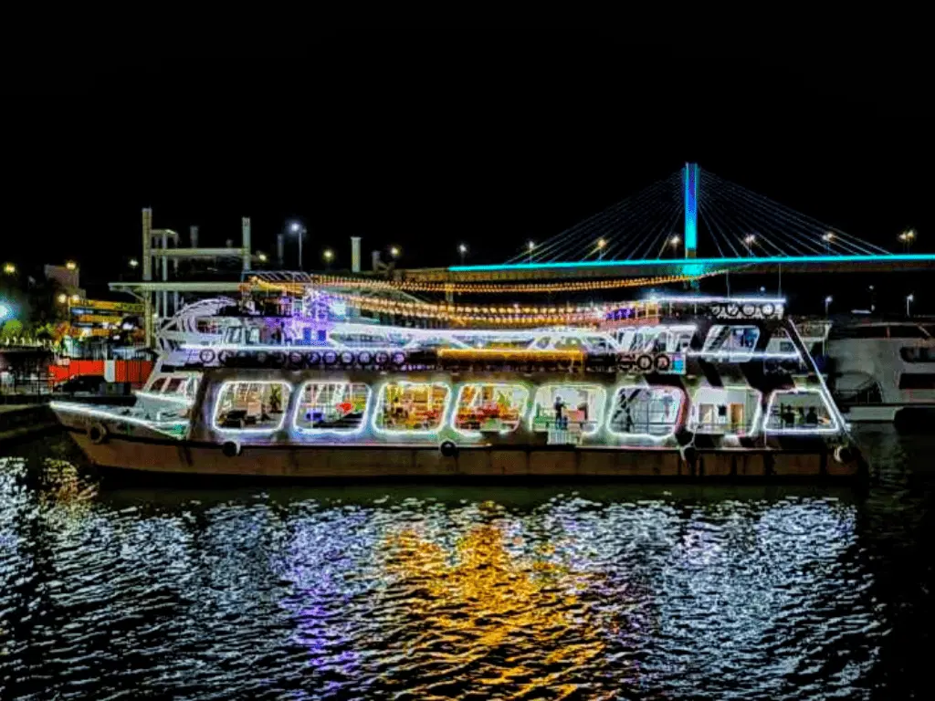 Princesa Dinner Cruise in Goa illuminated at night with colorful lights reflecting on the Mandovi River.